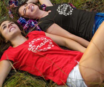 2 Frauen liegen zum JGA lachend im Gras und tragen JGA-Shirts T73